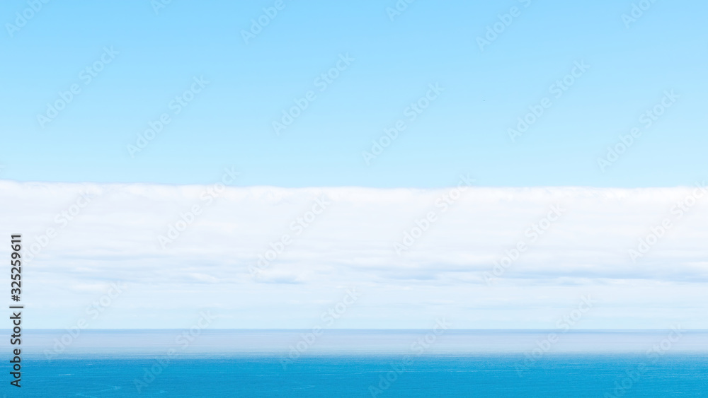 Long view of Pacific ocean horizon with white clouds