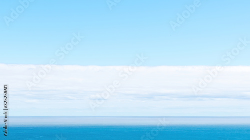 Long view of Pacific ocean horizon with white clouds