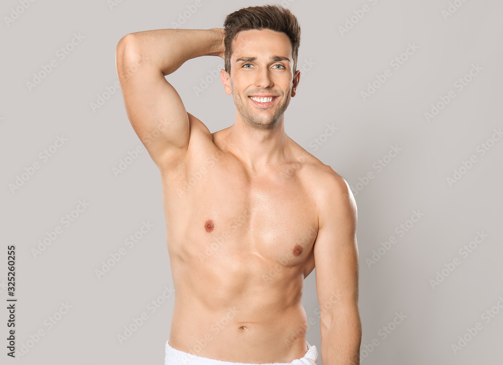 Handsome young man after depilation on grey background