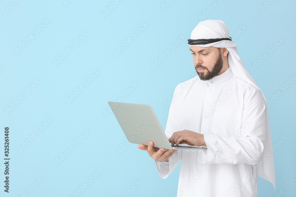 Arab businessman with laptop on color background Arab businessman with laptop on color background