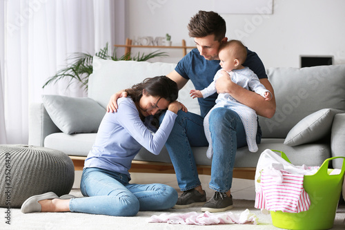 Stressed couple suffering from postnatal depression at home photo