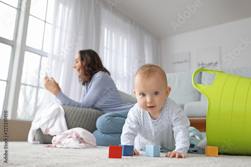 Photography Mischievous baby with careless young mother at home