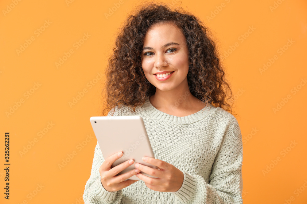 Young African-American woman with tablet computer on color background Young African-American woman with tablet computer on color background