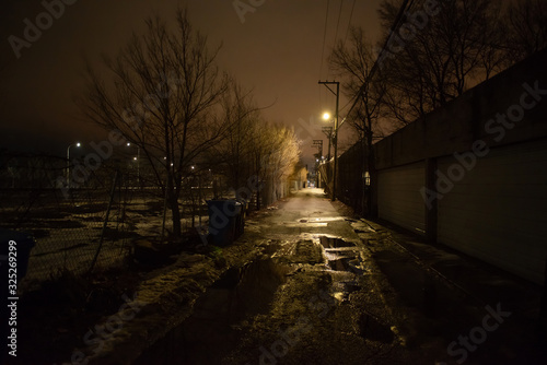 Fototapeta Naklejka Na Ścianę i Meble -  Dark and eerie urban city alley at night in the winter