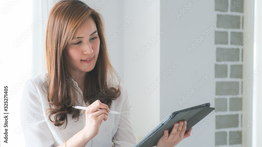 Business asian women use tablet computer sitting in white room Business asian women use tablet computer sitting in white room