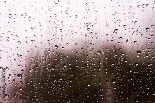 Textures of water droplets of rain flow down the windowpane. Rain drop on the car glass background  Blurred photo  Soft focus