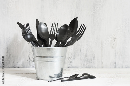 Set of black cutlery in galvanized bucket photo