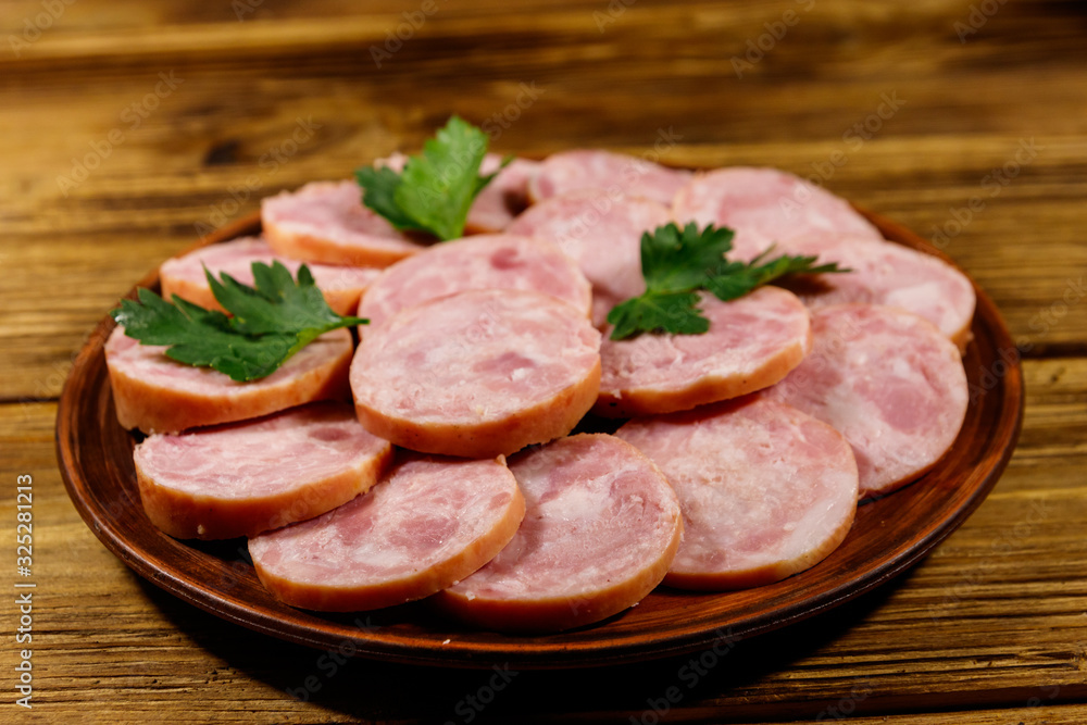 Ham sausage on a plate on wooden table