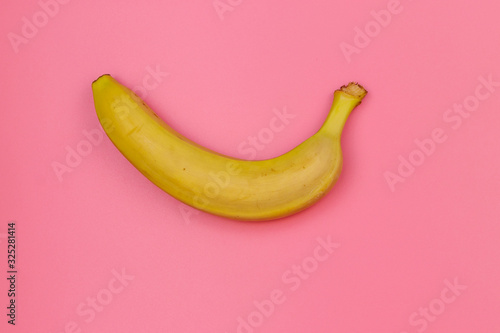 Yellow banana on pink background. Top view, flat lay, minimal design