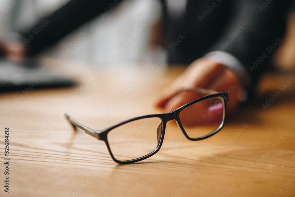 black-rimmed glasses lie on a table with a blurred background black-rimmed glasses lie on a table with a blurred background