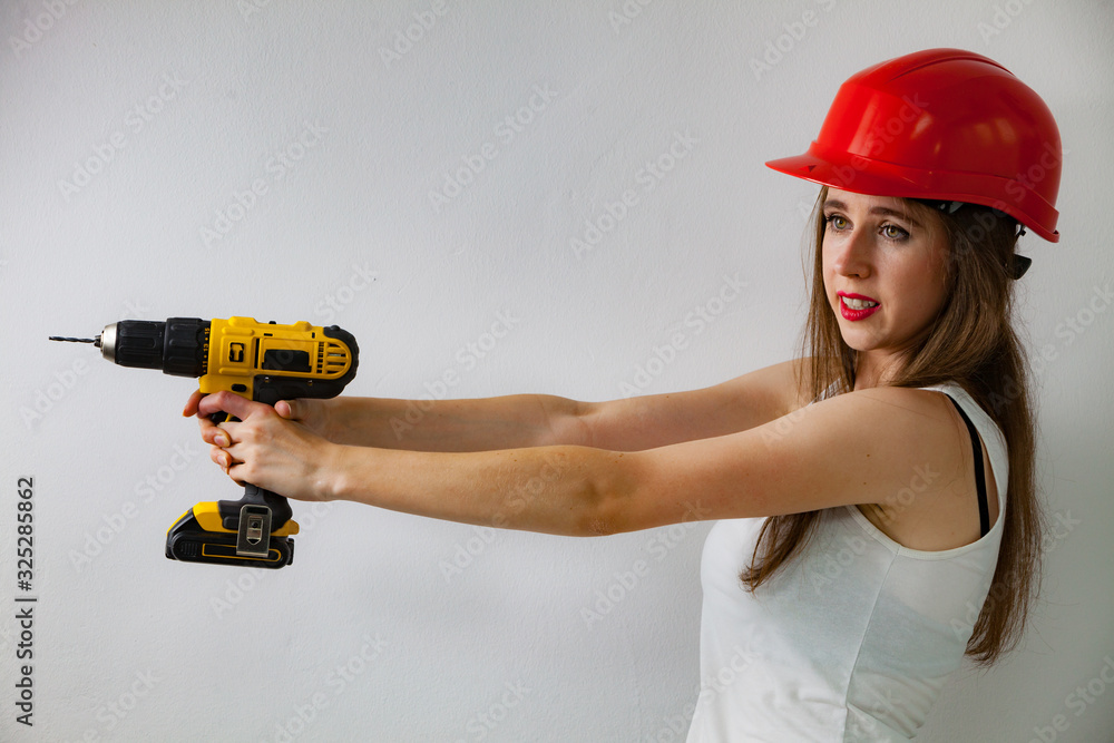 Woman using power driil for work at home