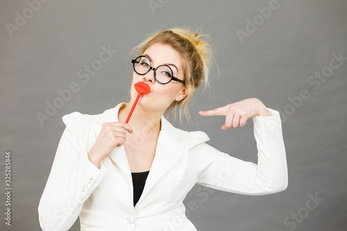 Happy elegant woman holding carnival accessoies on stick photo