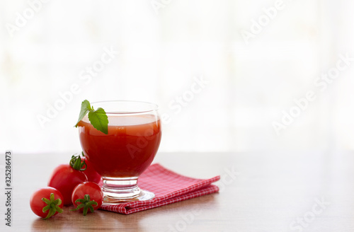 Tomato juice in glass with tomatoes on placema over wooden background. photo