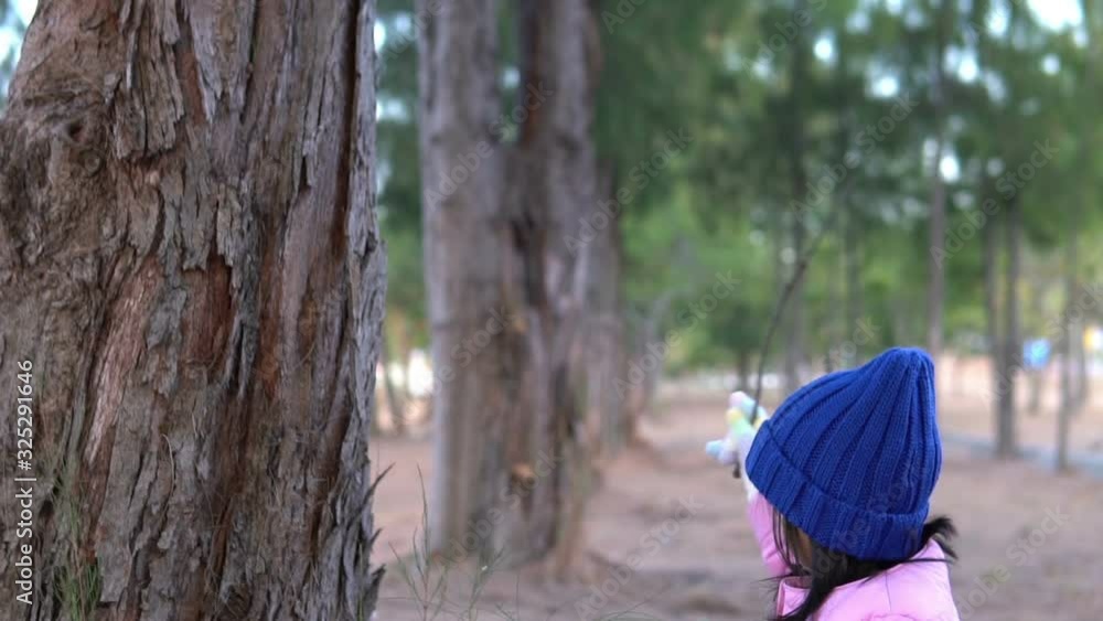 Portrait of cute asian little girl wear Winter clothes at the forest of the park,Thailand people pose for take a picture,Happy time Portrait of cute asian little girl wear Winter clothes at the forest of the park,Thailand people pose for take a picture,Happy time
