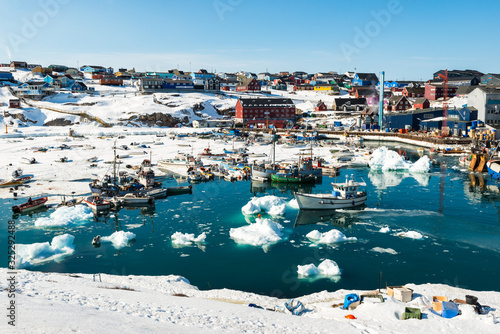 Boats moored in a snowy harbour at Ilulissat, Greenland.