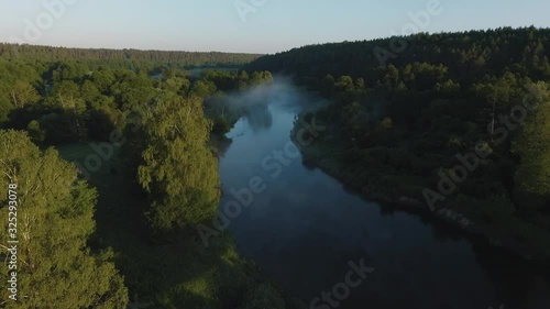 Cinematic early morning aerial flight over river Merkys valley, filled with fog and sun rays. Shot near Merkine town, not far from Druskininkai resort city. photo