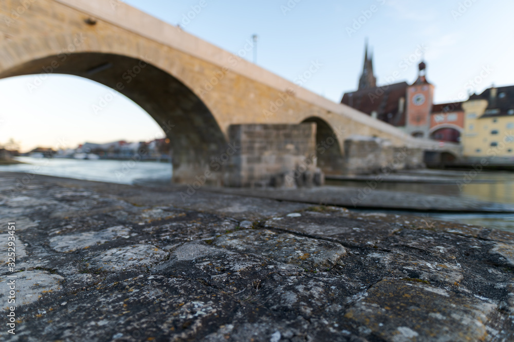 Stone bridge and skyline of Regensburg with selective focus on foreground