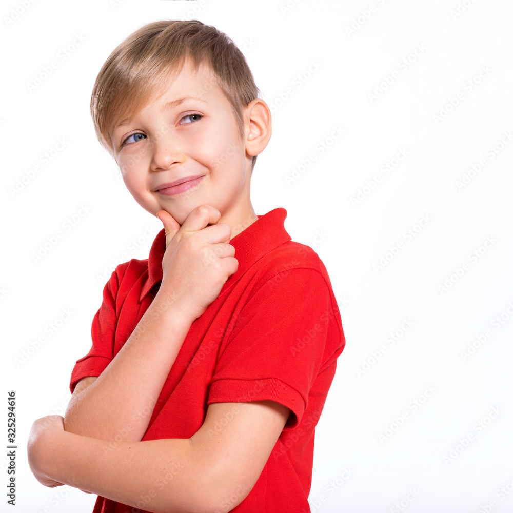 Portrait of white smiling kid in a red t-shirt looking away. Photo of a thinking boy looking away. Caucasian boy with a sly look, thinking about. Pretty kid with a easy smile Portrait of white smiling kid in a red t-shirt looking away. Photo of a thinking boy looking away. Caucasian boy with a sly look, thinking about. Pretty kid with a easy smile