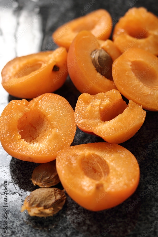 Fresh apricot halves on granite table