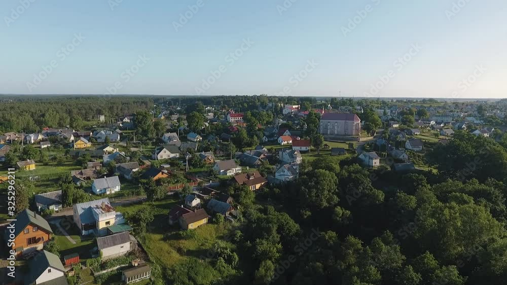 Beautiful aerial flight over Merkine town not far from Druskininkai resort city, Lithuania. Shot during early summer morning. Town on the bank of River Nemunas and Merkys. Surrounded by pine forest.