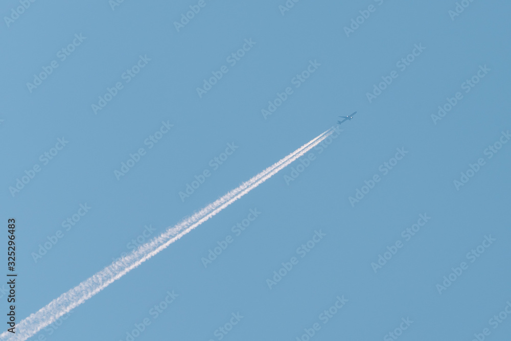 Jet passenger plane with reversing trail on a background of blue sky Jet passenger plane with reversing trail on a background of blue sky