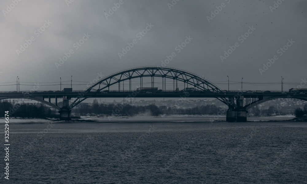 Road bridge in cloudy weather on the background of the Moscow river.