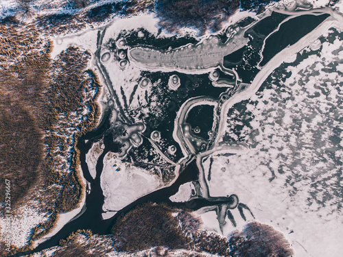 A frozen pond photographed from a quadrocopter from top to bottom and having natural patterns. Winter. Russia. © Andrey