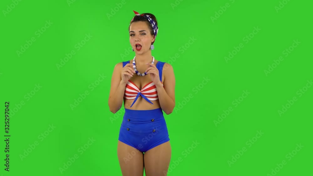 Beautiful girl in a swimsuit seductively smiling and gesture threatens by shaking her index finger. Green screen Beautiful girl in a swimsuit seductively smiling and gesture threatens by shaking her index finger. Green screen