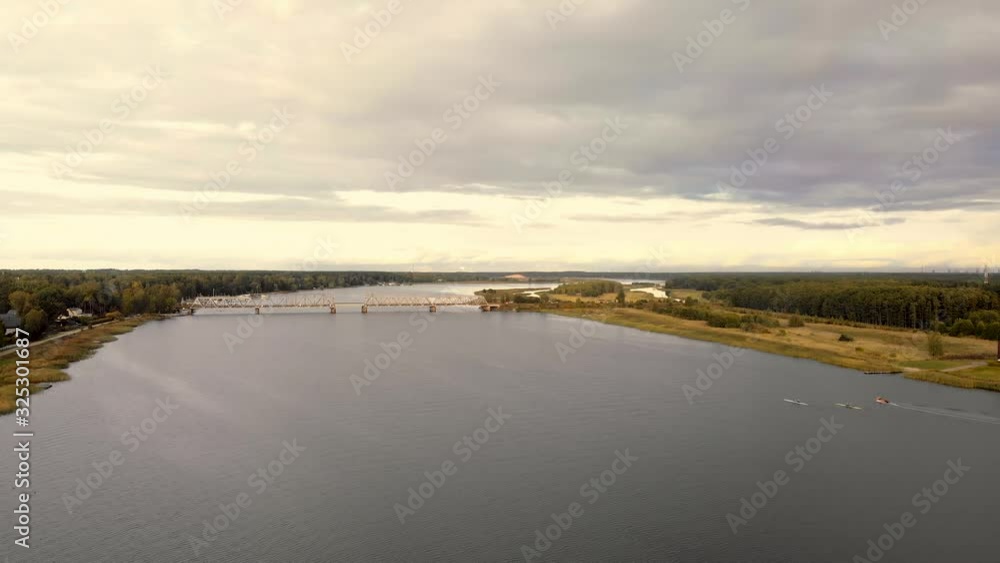 Aerial view of train passing bridge over river Lielupe and competing rowing boats Aerial view of train passing bridge over river Lielupe and competing rowing boats
