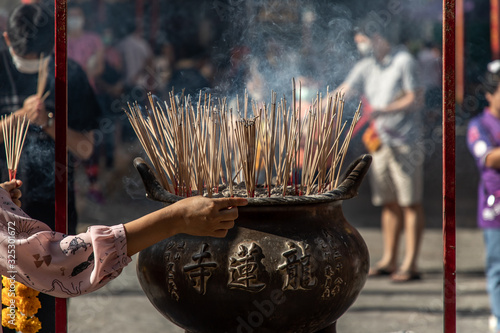Canvas Print Incense burning with white smoke in an incense pot at a temple in Wat Mangkon Kamalawat