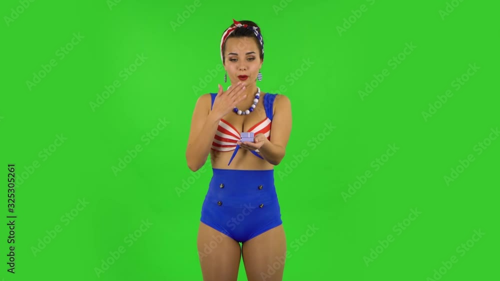 Beautiful girl in swimsuit is opening small box with surprise and rejoicing. Greenscreen Beautiful girl in swimsuit is opening small box with surprise and rejoicing. Greenscreen