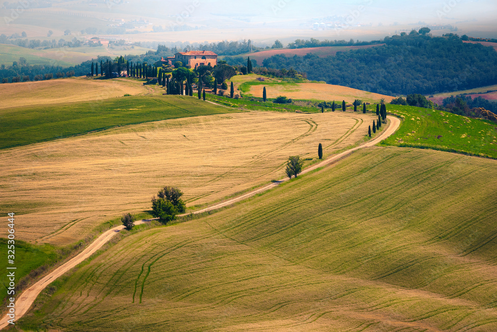 Admirable misty Tuscany landscape with rural curved road, Italy