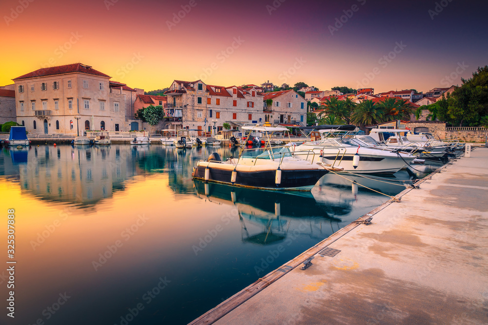 Anchored motorboats in the harbor of Trogir at sunrise, Croatia