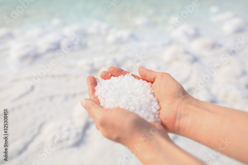 Close-up of the salt from the Death Sea in Jordan in woman<s hands. Atopic skin care. 