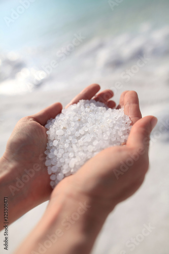 Close-up of the salt from the Death Sea in Jordan in woman<s hands .