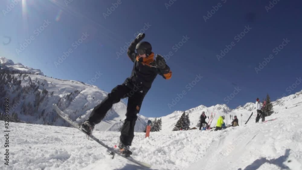 Happy youth snowboarder jumps while his friends are watching Happy youth snowboarder jumps while his friends are watching
