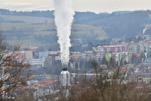 White smoke comes from the chimney of a power plant to produce heat in winter for houses and apartment buildings