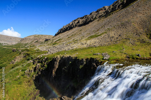 Der Dynjandi Wasserfall, einer der schönsten Wasserfälle Islands im Norden der Insel in den Westfjorden, vor blauem Himmel