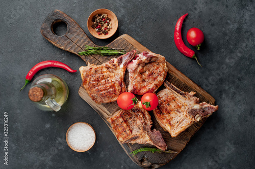 grilled beef steak with spices on a cutting board on a stone background