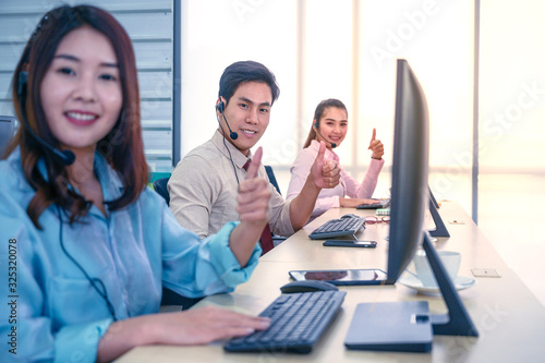 Group of young teamwork businesspeople Thumbs up with headset and computer at office.