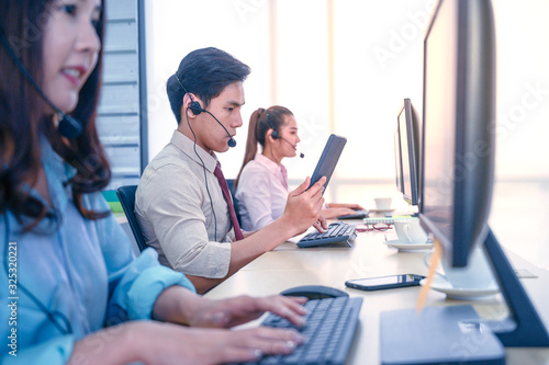 Group of young teamwork businesspeople with headset and computer at office.