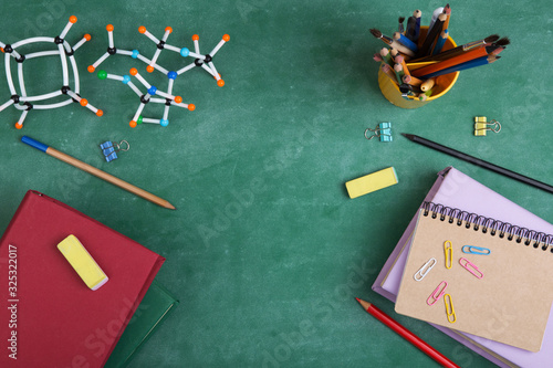 Education concept - books and molecule model on the desk in the auditorium
