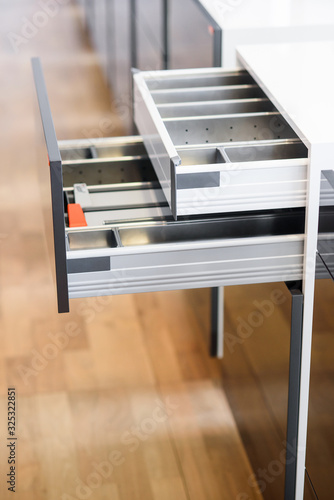 Opened kitchen drawer with cutlery tray. Two drawers are hide behind the high front. Smart storage solution.
