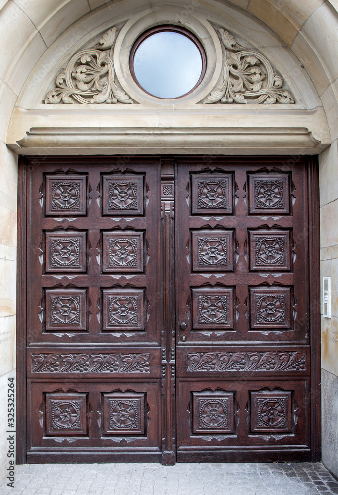 Wooden arched doors surrounded by stones in medieval design