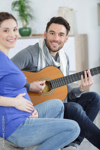 smiling couple with guitar at home