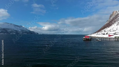 Slow aerial shot of Rekvik port flying above blue sea water in northern Norway, Europe photo