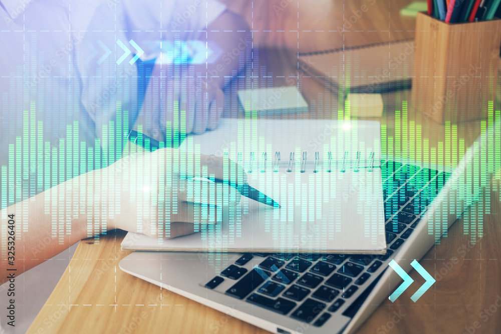 Financial charts displayed on woman's hand taking notes background. Concept of research. Double exposure Financial charts displayed on woman's hand taking notes background. Concept of research. Double exposure