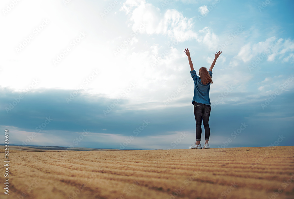 Happy woman in desert with raised hands against dramatic sky, copy space. Happy woman in desert with raised hands against dramatic sky, copy space.
