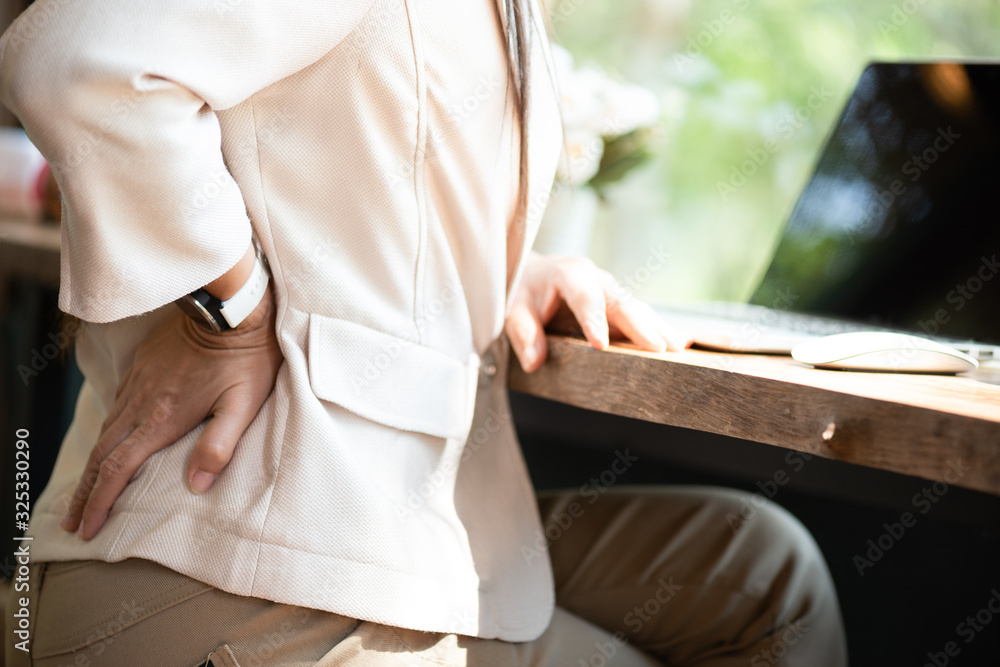 Obraz premium Closeup woman with hands holding her back pain. Office syndrome and Healthcare Concept.