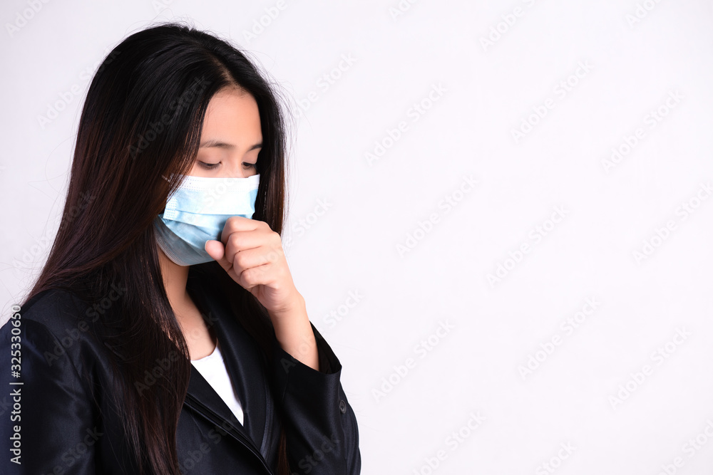 Close up of a businesswoman in a suit wearing Protective face mask and cough, get ready for Coronavirus and pm 2.5 fighting against on gray background. Close up of a businesswoman in a suit wearing Protective face mask and cough, get ready for Coronavirus and pm 2.5 fighting against on gray background.